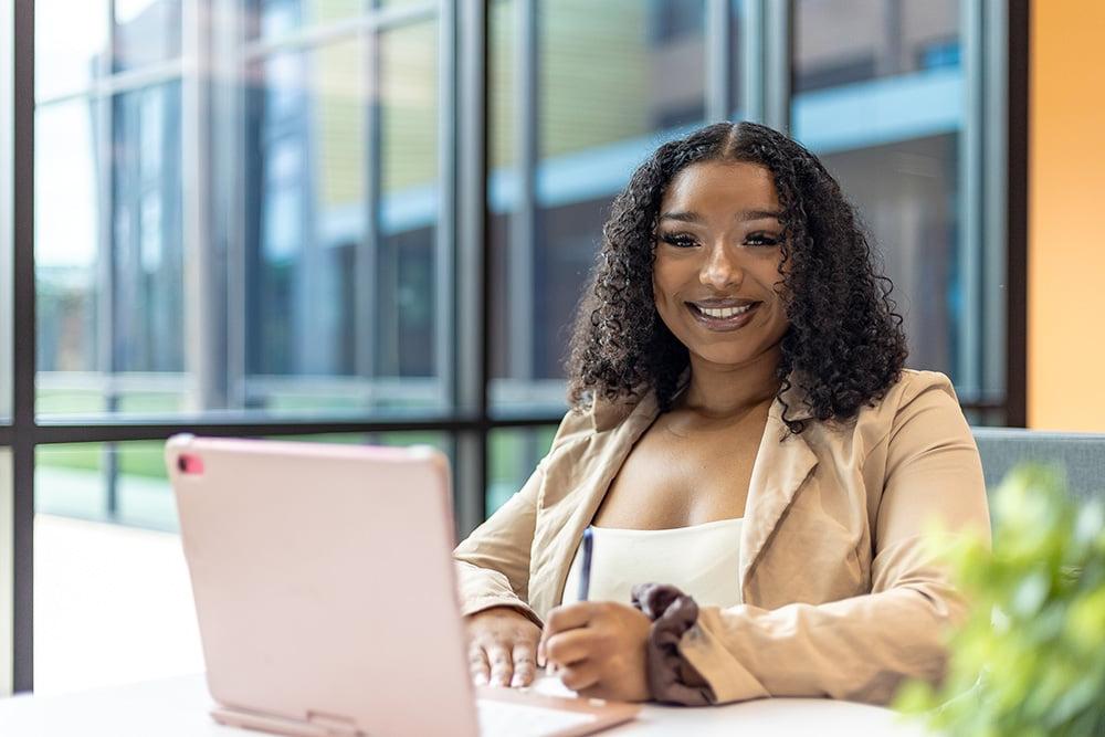 Student Brianna Jones sitting in front of a laptop and smiling